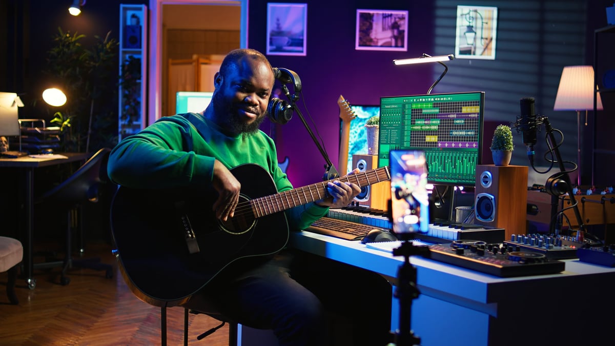 Musician working on music in a studio, headphones around the neck